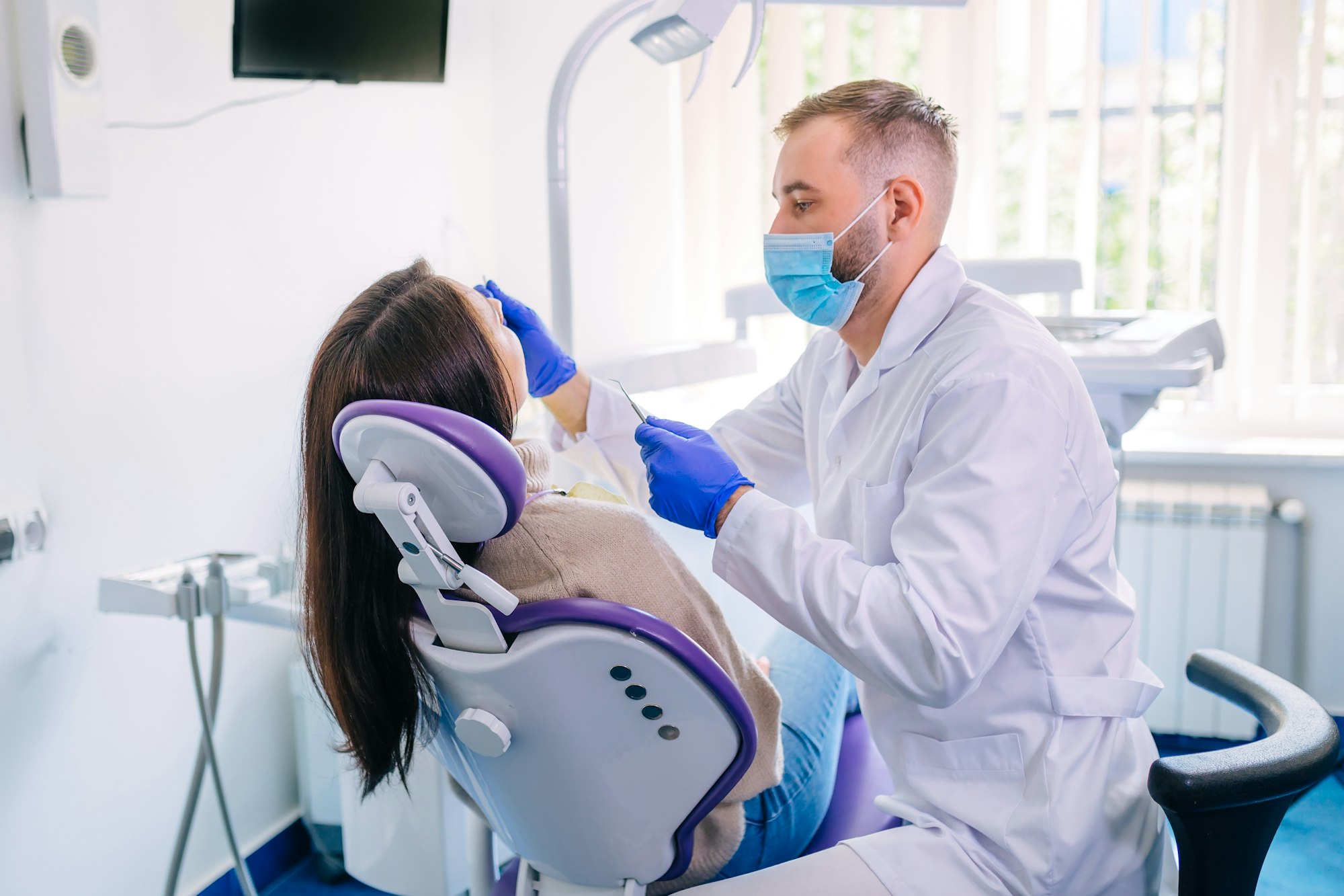 female sits in dentist chair and undergo dentist examining. dent