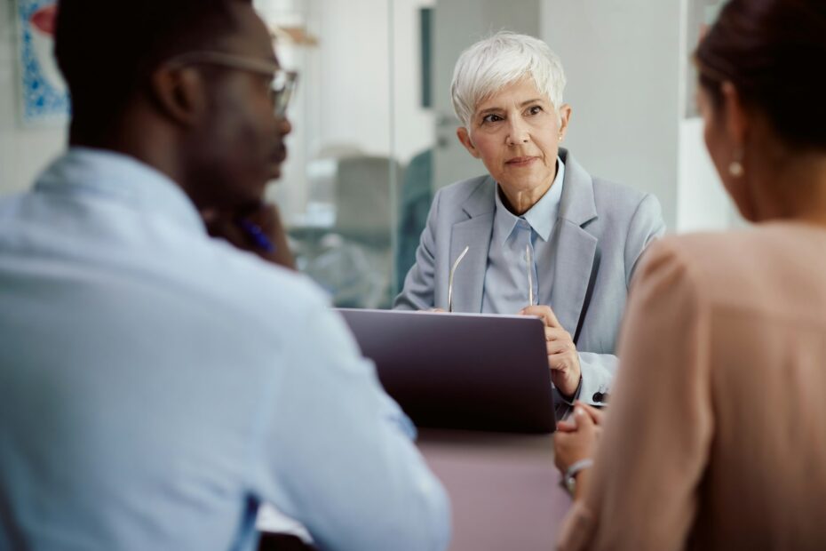 Mature financial advisor having meeting with her clients in the office.